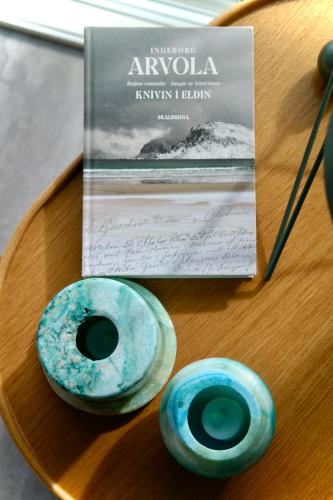 two donuts sitting on a table next to a book at Beitisstova - Mesmerizing Sea & Mountain Views in Stykkið