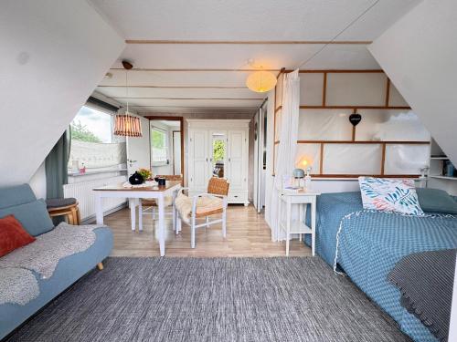a living room with a couch and a table at Nordlicht, 1-Zimmer mit Meerblickbalkon 500 m zum Strand in Westerholz