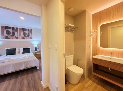a bedroom with a bed and a bathroom with a sink at AL Ponto Norte in Melgaço