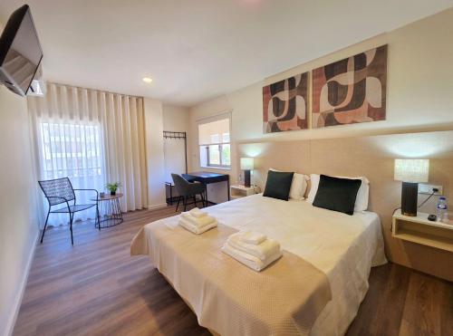 a bedroom with a large bed with towels on it at AL Ponto Norte in Melgaço