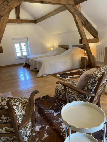 a bedroom with a bed and chairs in a room at Le marcquis in Marcq