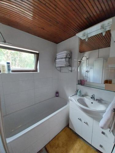 a white bathroom with a tub and a sink at Buda Weekend House in Budapest