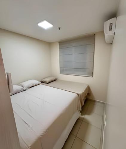a small bedroom with a bed and a window at Até 4 Hóspedes, Elevador, Varanda C/Frente Piscina Jr Catito in Brasília