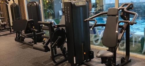a row of tread machines in a gym with a swimming pool at Double Room with Private Bathroom near Dubai in Sharjah
