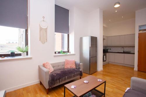a living room with a couch and a table at Stunning City Centre Duplex in Glasgow