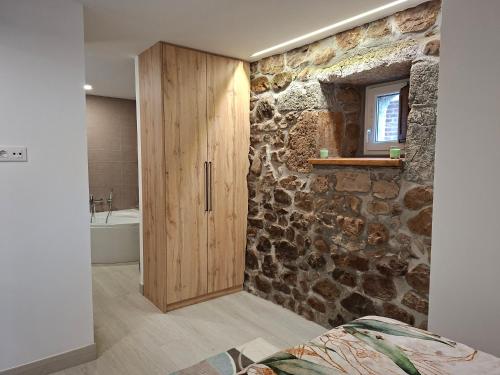 a bathroom with a stone wall and a wooden cabinet at La Capital del Mundo in Arredondo