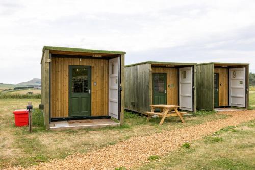 a row of wooden huts in a field at Container 1, Camp Tapnell in Yarmouth