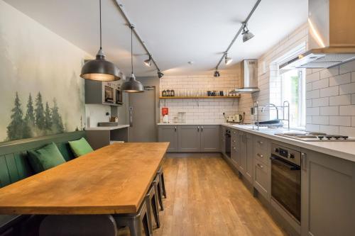a large kitchen with a wooden table and a counter at Big Lodge in Peebles