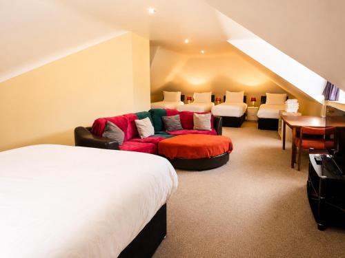 a room with two beds and a couch and a desk at Moorepark West House in Fermoy