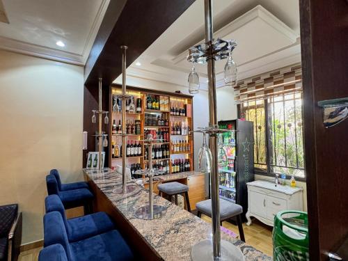 a bar with blue chairs and a counter in a room at Otk's Apartment in Abuja