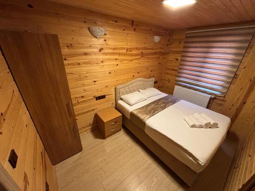 a bedroom with a bed in a wooden room at EŞ Pansiyon in Uzungöl