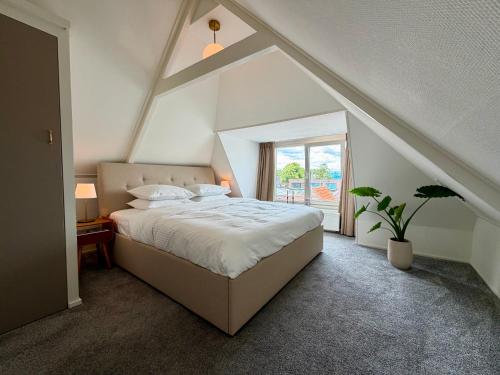 a bedroom with a large bed and a window at Maison Bo Luxury Stay in Historic Lemmer in Lemmer