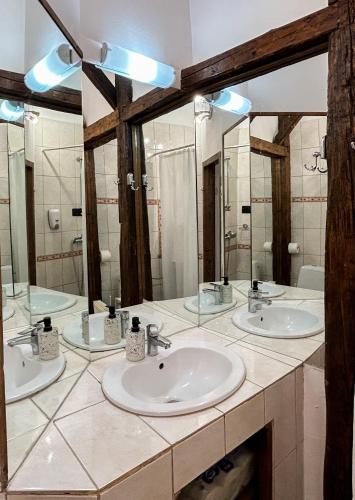 a bathroom with three sinks and a large mirror at Casa Cojo in Sighişoara