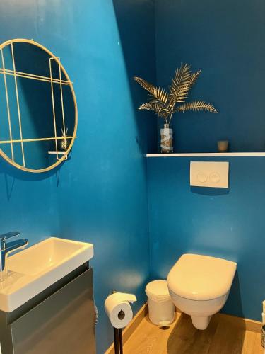 a blue bathroom with a toilet and a sink at Pavillon d'Éole in Berck-sur-Mer