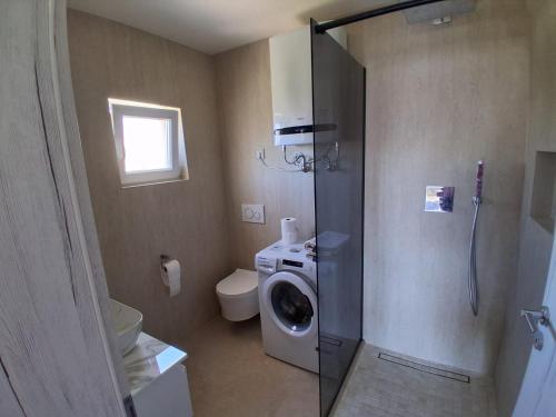 a bathroom with a washing machine and a washer at Apartment Matija in Stara Novalja