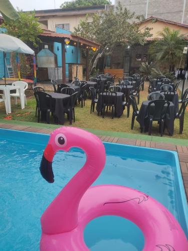 a pink flamingo swimming in a pool with a restaurant at Casa com Natureza in Goiânia