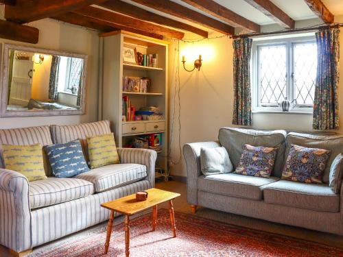 a living room with two couches and a table at Pond Cottage in Alton