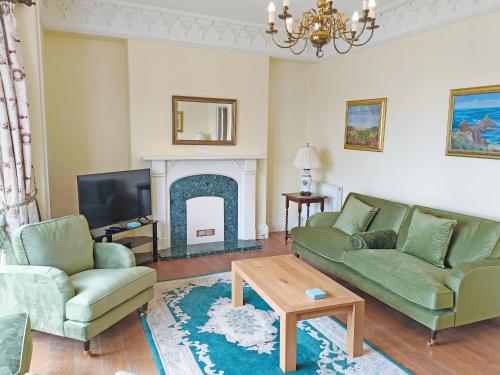 a living room with a couch and a fireplace at The Captains House in Instow