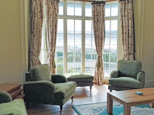 a living room with chairs and a large window at The Captains House in Instow