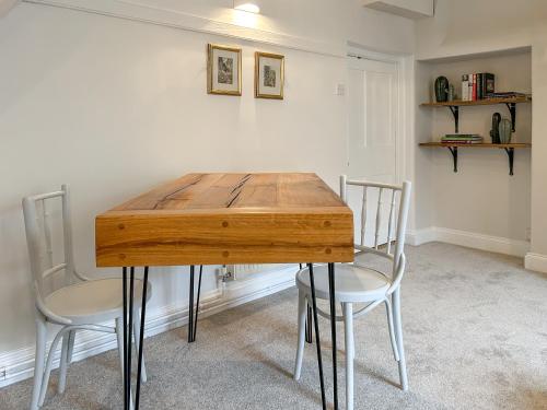 a wooden table and two chairs in a room at Rectory Cottage in Isham