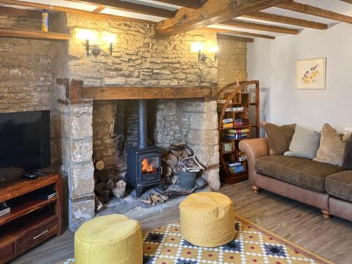 a living room with a fireplace and a couch at The Farmhouse - Uk50909 in Thornhaugh