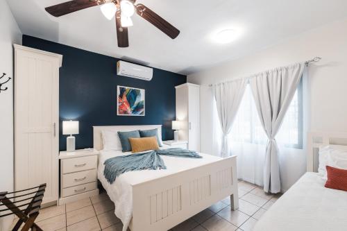 a bedroom with a white bed and a blue wall at Coco Garden Suites in Coco