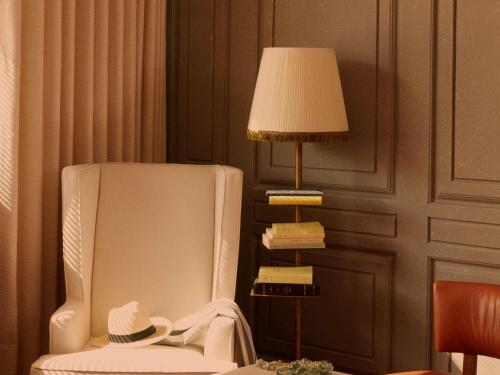 a room with a chair and a lamp and a hat at Mondrian Bordeaux Les Carmes in Bordeaux
