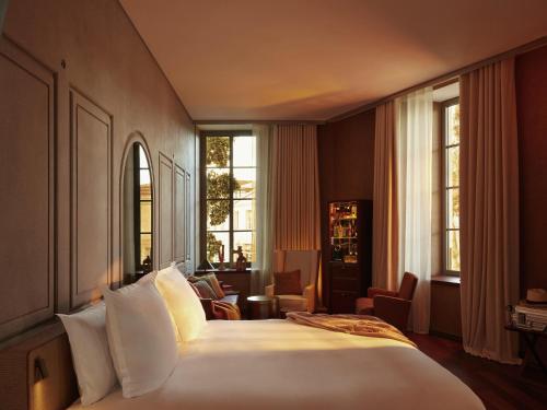 a hotel room with a large bed and windows at Mondrian Bordeaux Les Carmes in Bordeaux