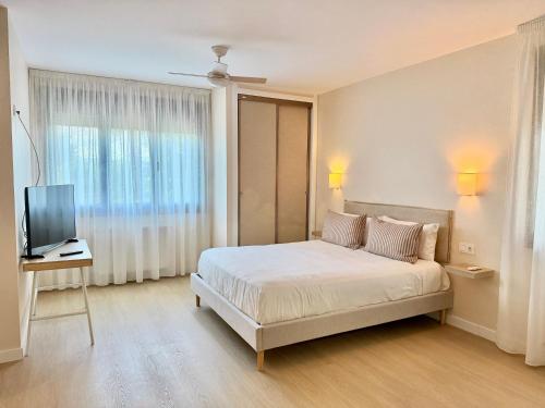 a bedroom with a bed and a television in it at Hostal Finca La Oliva in Oleiros