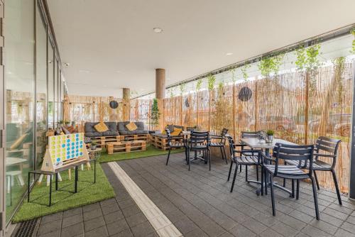 a patio with tables and chairs and a couch at Appart'City Confort Mulhouse in Mulhouse