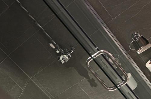 a shower in a bathroom with a shower head at The Penny Farthing Hotel in Berkhamsted