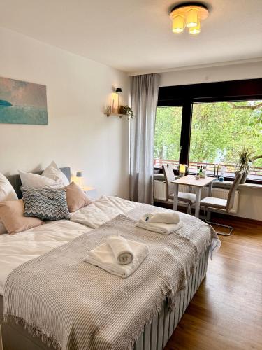 a bedroom with a bed with two towels on it at Uferglanz - Balcony, view, sparkling wine, snacks in Koblenz