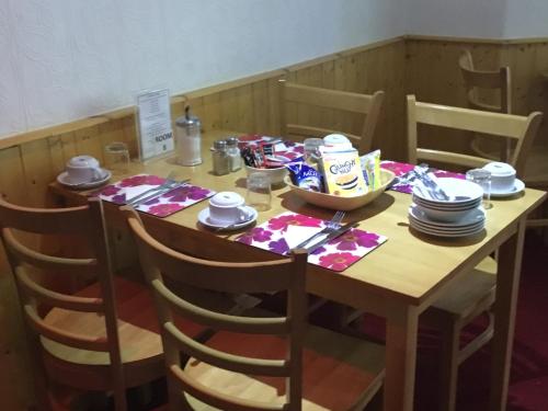a wooden table with plates and dishes on it at The Danescourt in Blackpool