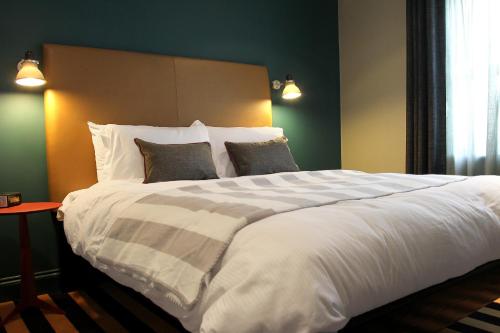 a bedroom with a large white bed with two pillows at The Penny Farthing Hotel in Berkhamsted