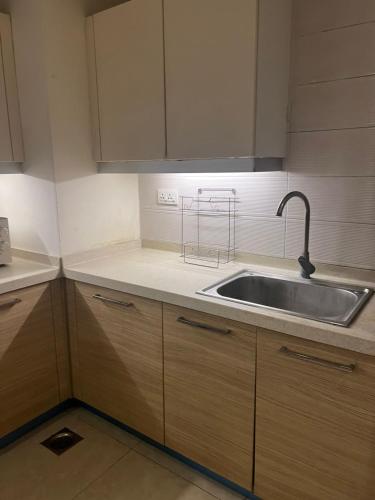 a kitchen with a sink and wooden cabinets at Serene Comfort Suites in Rawalpindi