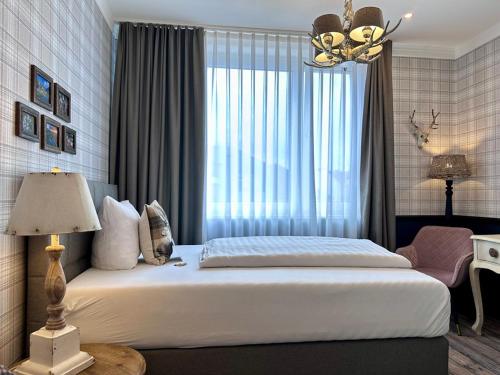 a bedroom with a large bed and a window at Designhotel Central Fulda in Fulda