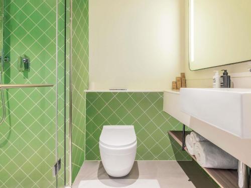 a bathroom with a toilet and a sink and a shower at ibis Styles Goa Vagator - An Accor Brand in Vagator