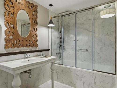 a bathroom with a shower and a sink and a mirror at Rixos Bab Al Bahr in Ras al Khaimah