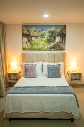 a bedroom with a bed with a painting on the wall at La Malena, Casa Hotel in Valledupar
