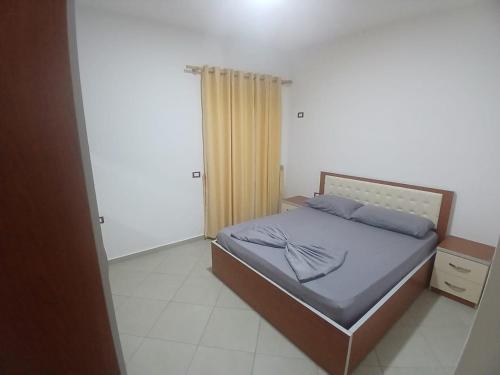 a small bedroom with a bed with blue pillows at Rana E Hedhun Llugani Apartments in Lezhë