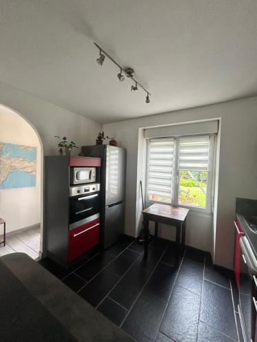 a kitchen with a stove and a table in it at Maison avec jardin in Crozon