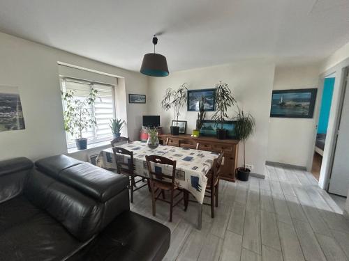 a living room with a table and a couch at Maison avec jardin in Crozon