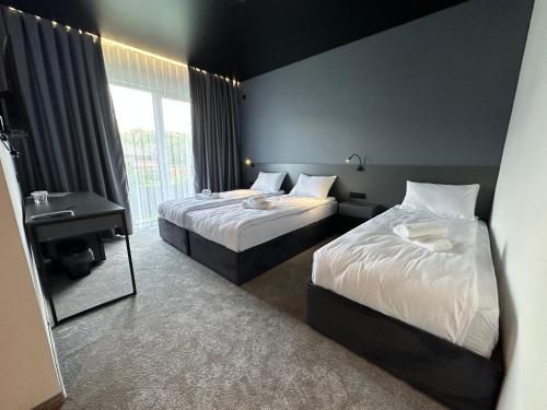 a bedroom with two beds and a sink and a mirror at Gravity Resort & Spa in Solotvyno