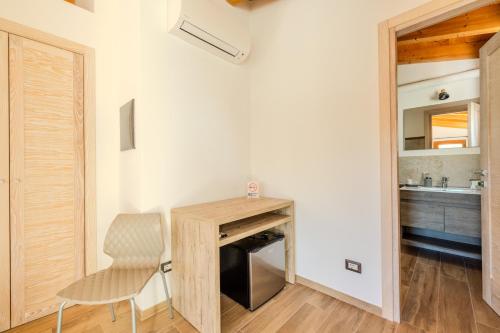 a room with a desk and a chair and a kitchen at S'istella suite in Olbia
