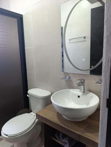 a bathroom with a sink and a toilet and a mirror at Departamento comodo en Ubicacion Privilegiada in Mérida
