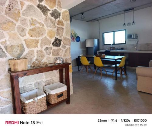 a living room with a table and a stone wall at Departamento comodo en Progreso 1 Recamara 3 personas in Progreso