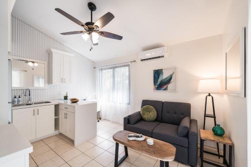a living room with a couch and a kitchen at Coco Garden Suites in Coco
