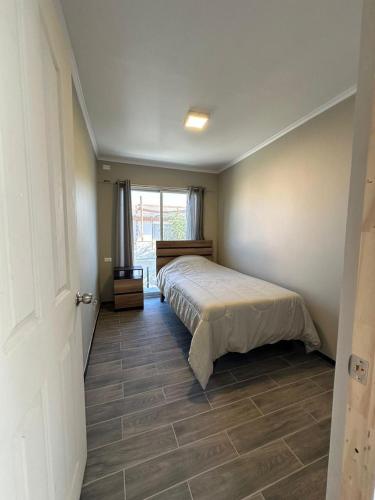 a bedroom with a bed and a large window at Casa & Habitaciones in Mejillones