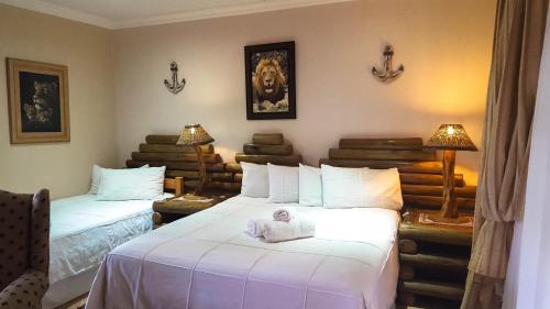 a room with two beds with a baby sitting on them at Aark Guest Lodge in Vanderbijlpark
