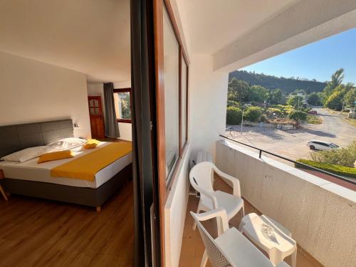 a bedroom with a bed and a large window at Palma Beach Hotel in Kranevo